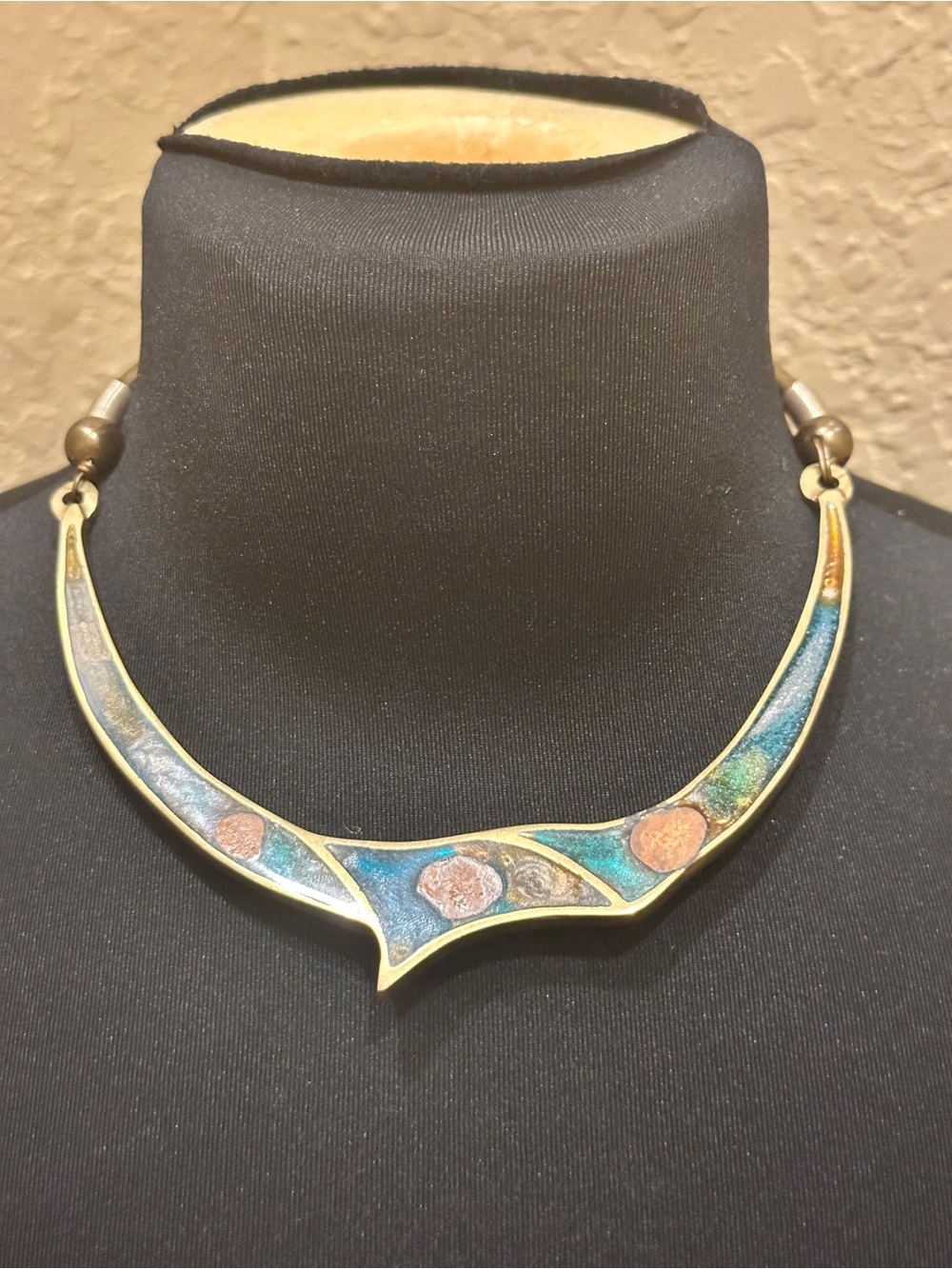 Vintage brass torque or collar necklace featuring a crescent-shaped bib